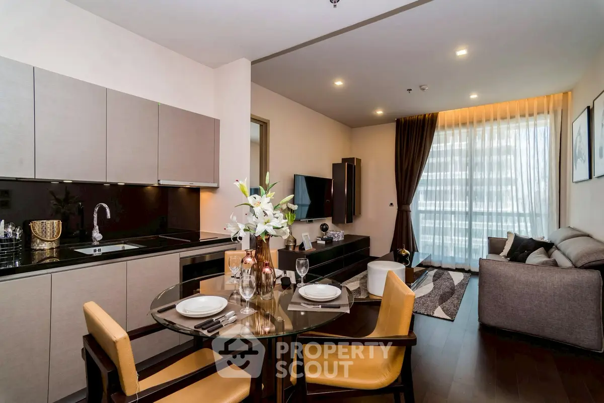 Modern open-plan living room and kitchen with elegant decor and natural light.