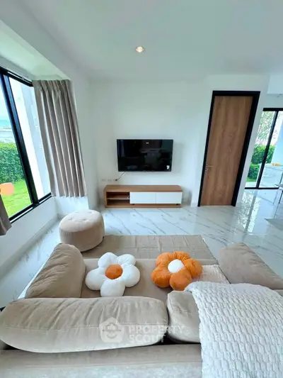 Modern living room with stylish decor and large windows offering natural light and garden view.