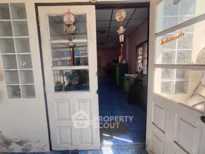 Charming entrance to a cozy home with blue tiled flooring and decorative door accents.