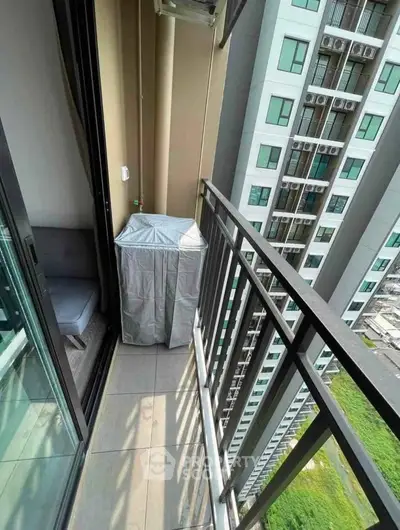 Modern apartment balcony with city view and outdoor seating area.