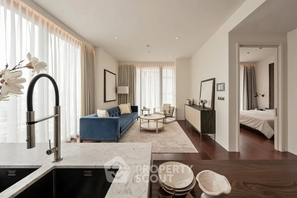 Luxurious modern living room with elegant decor and open layout, featuring a cozy bedroom view.