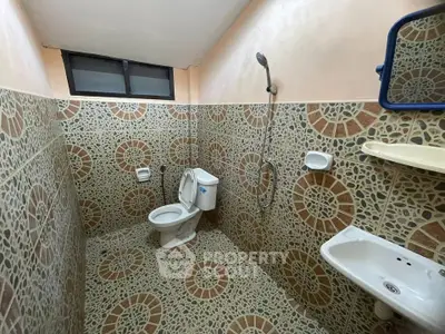 Spacious bathroom with unique tile design and modern fixtures