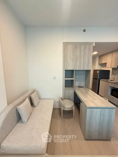 Modern apartment interior with sleek kitchen and cozy living area, featuring contemporary furniture and appliances.