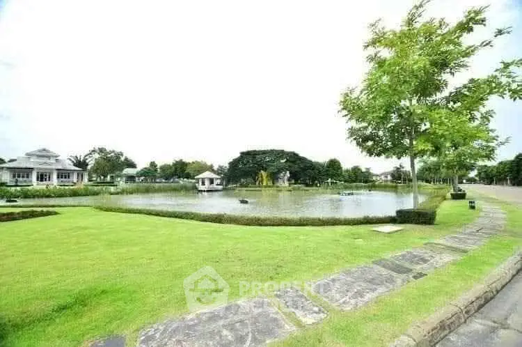 Stunning lakeside view with lush greenery and elegant homes, perfect for serene living.