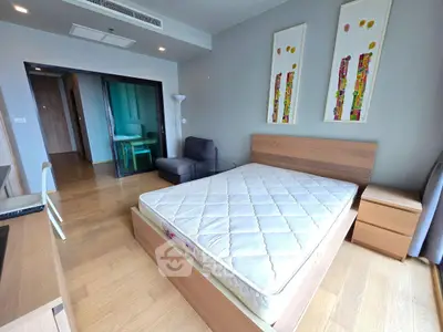 Modern bedroom with wooden flooring and stylish decor in a contemporary apartment.