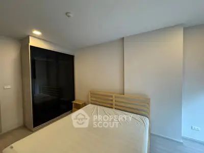 Modern minimalist bedroom with sleek wardrobe and cozy bed in a bright apartment.