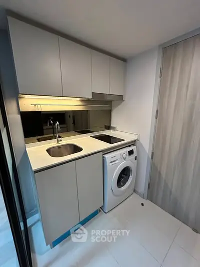 Modern compact kitchen with washing machine and sleek cabinetry