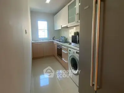 Modern kitchen with sleek appliances and ample natural light