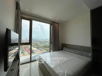 Modern bedroom with stunning city view and large window in high-rise apartment.