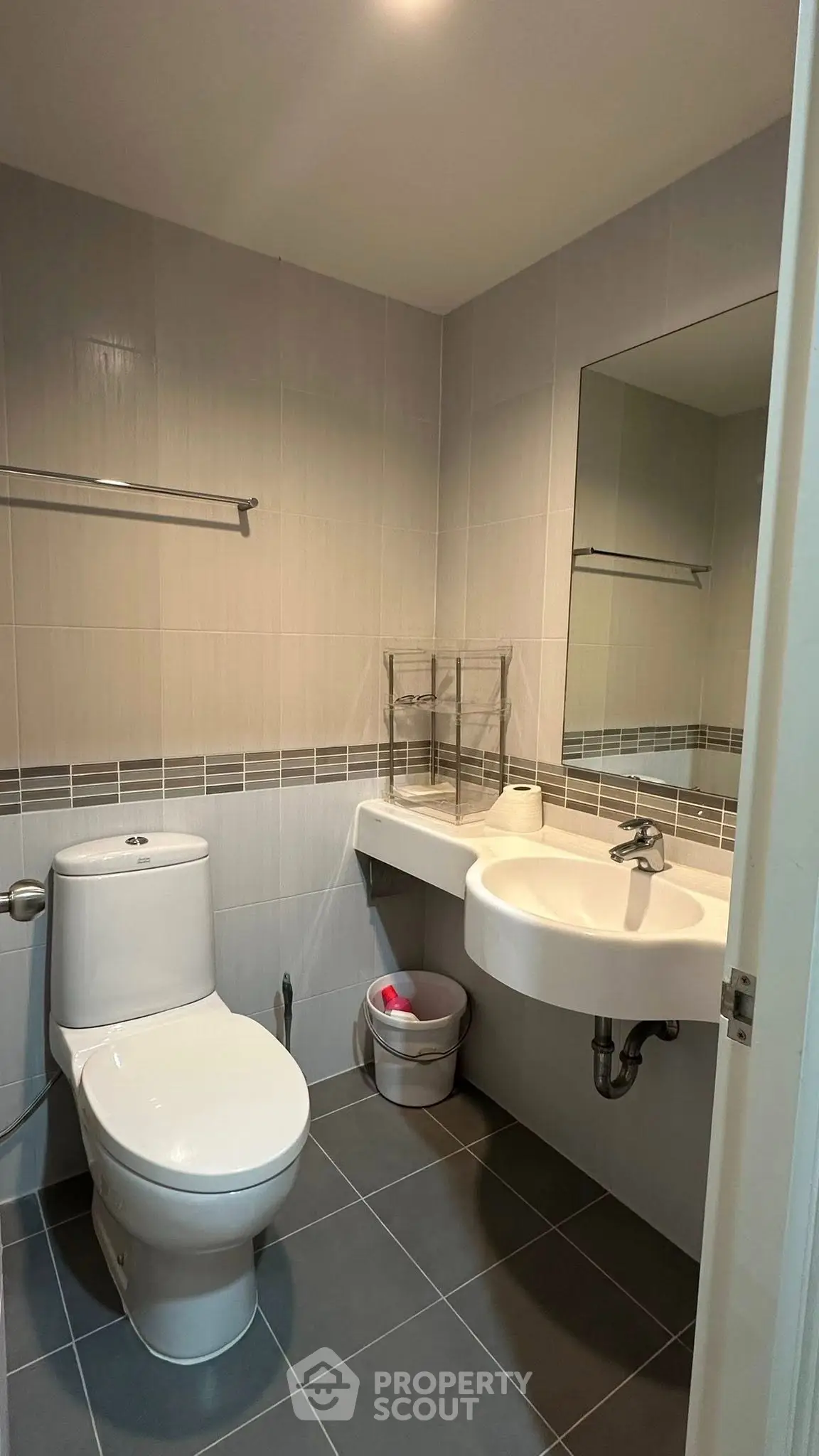 Modern bathroom with sleek fixtures and neutral tiles, featuring a spacious layout and contemporary design.