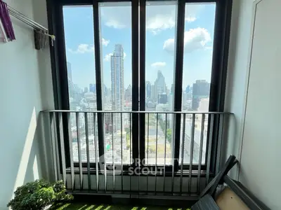 Stunning city view from a high-rise balcony with modern railing and artificial grass flooring.