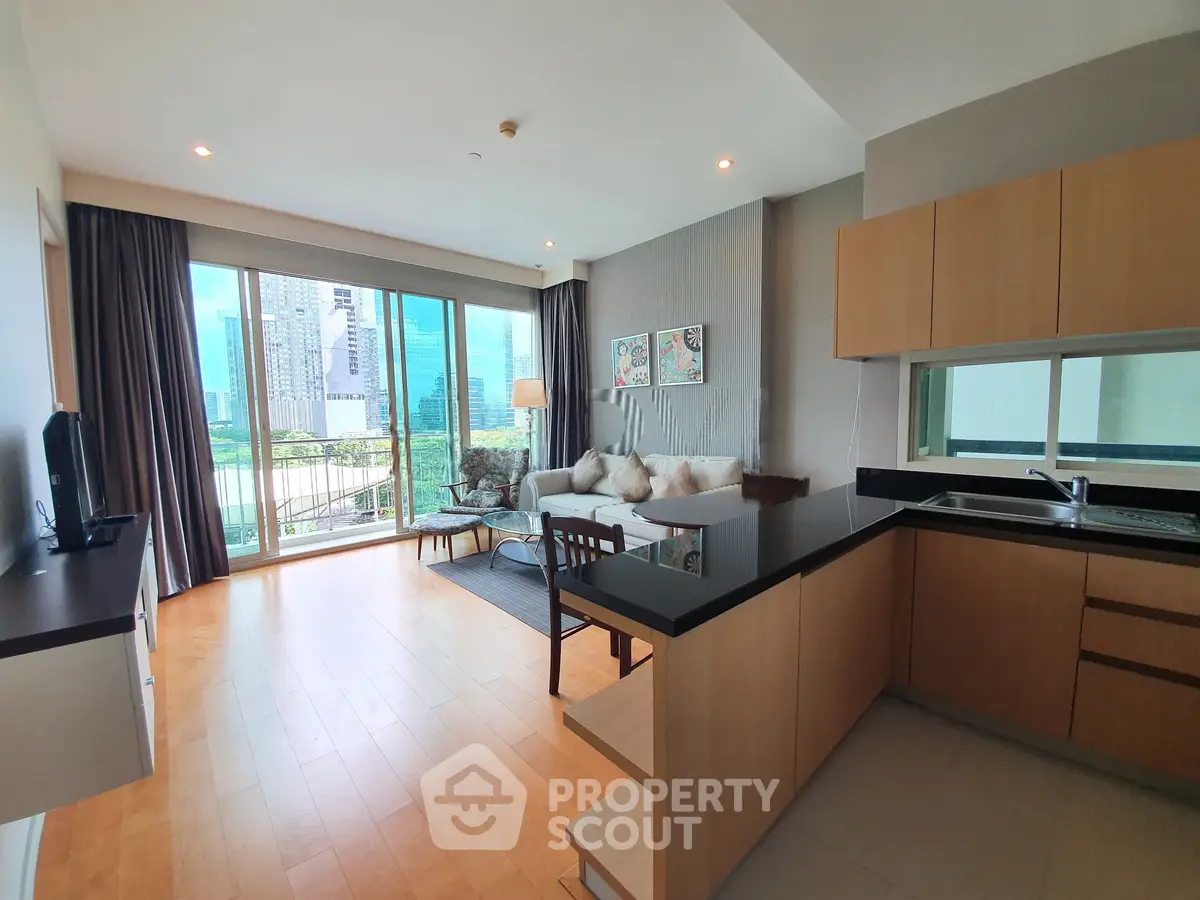 Spacious modern living room with open kitchen and city view, featuring elegant wooden flooring and large windows.