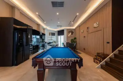 Luxurious open-plan living area with pool table and modern kitchen