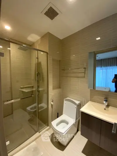 Modern bathroom with glass shower and sleek fixtures in luxury apartment