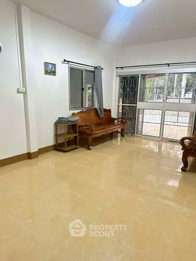 Spacious living room with elegant wooden furniture and large windows for natural light.