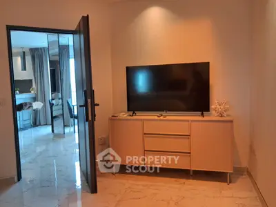 Modern living room with sleek TV stand and open doorway to elegant interior