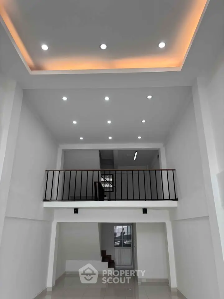 Modern interior with high ceiling and recessed lighting in a spacious living area.
