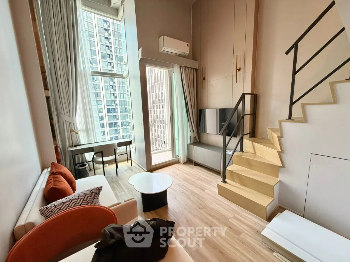 Modern loft apartment with high ceilings, large windows, and stylish staircase in urban setting.