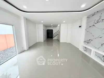 Spacious modern living room with sleek marble accent wall and glossy tile flooring