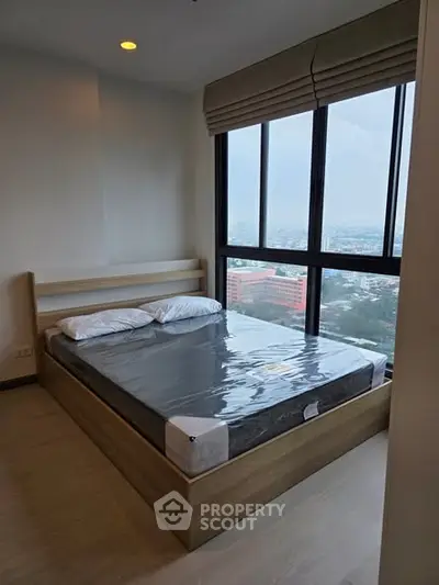 Modern bedroom with large windows offering stunning city views