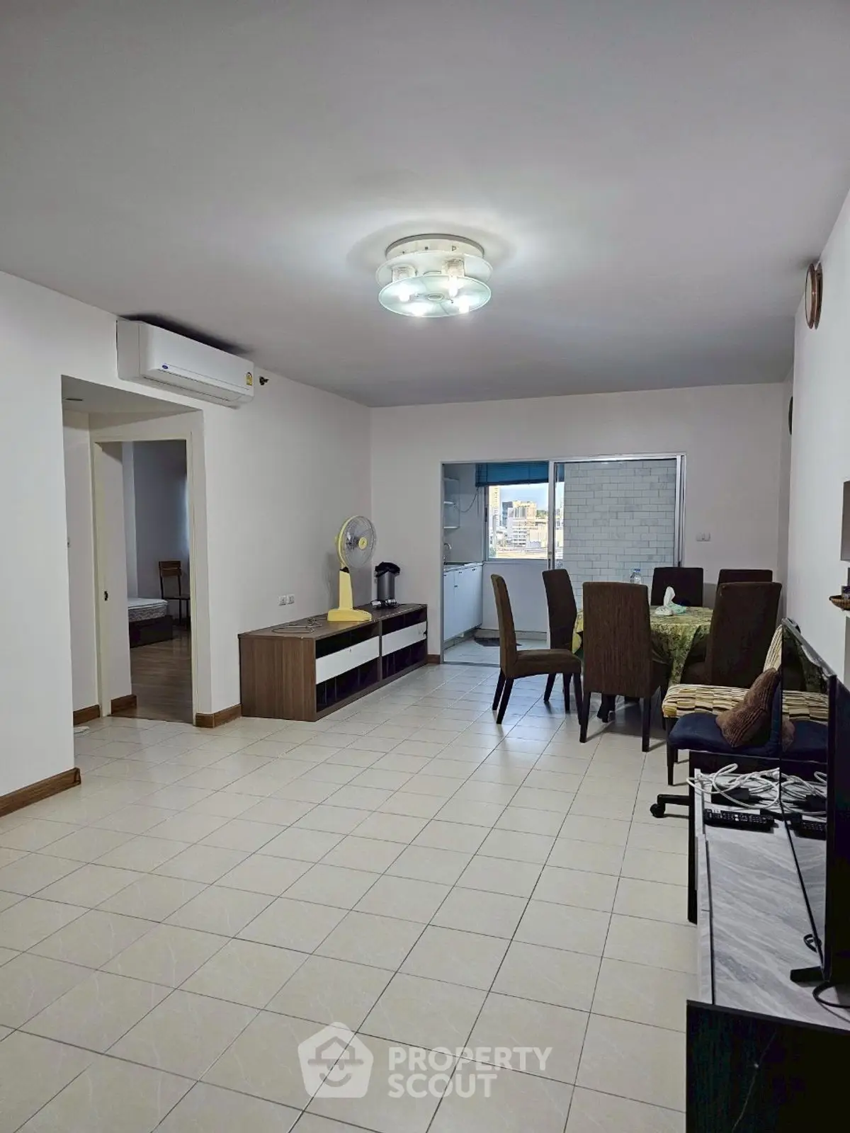 Spacious open-plan living and dining area with modern furnishings and tiled flooring.
