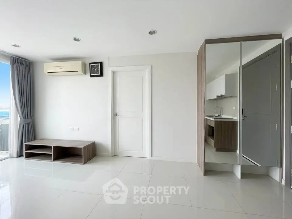 Modern minimalist apartment interior with sleek kitchen and bright living area.
