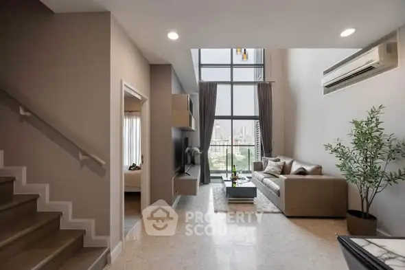 Spacious modern living room with high ceilings and city view, featuring elegant decor and natural light.