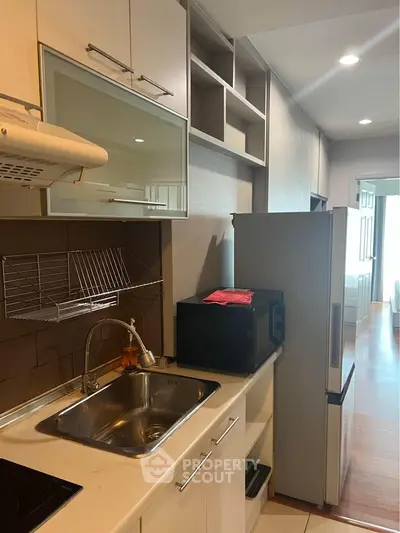 Modern kitchen with sleek cabinetry and stainless steel appliances in a stylish apartment.