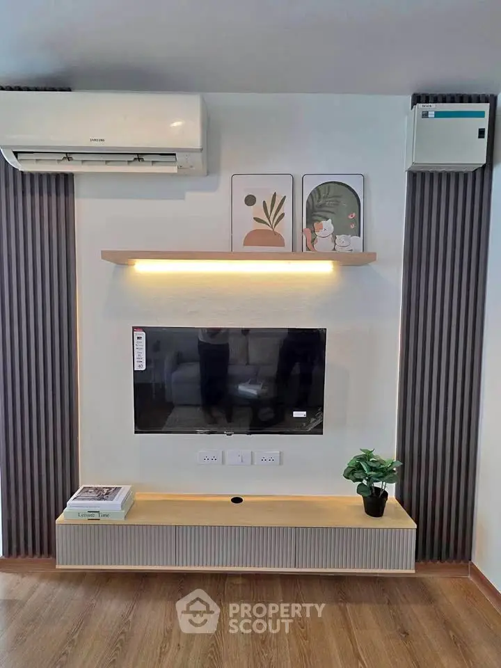 Modern living room with wall-mounted TV, air conditioning, and stylish decor.