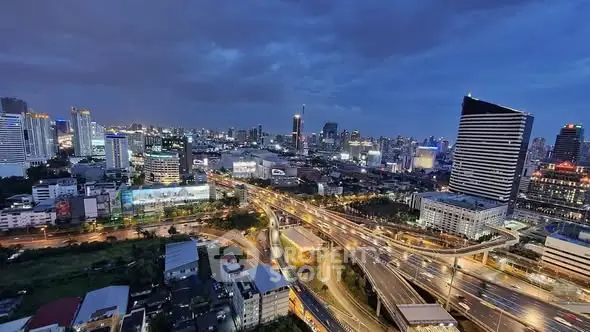 Stunning cityscape view showcasing vibrant urban skyline at dusk with illuminated buildings and highways.
