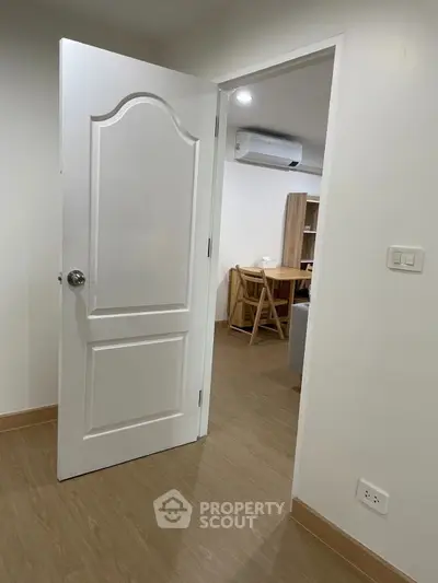 Modern apartment interior with open door leading to cozy living area