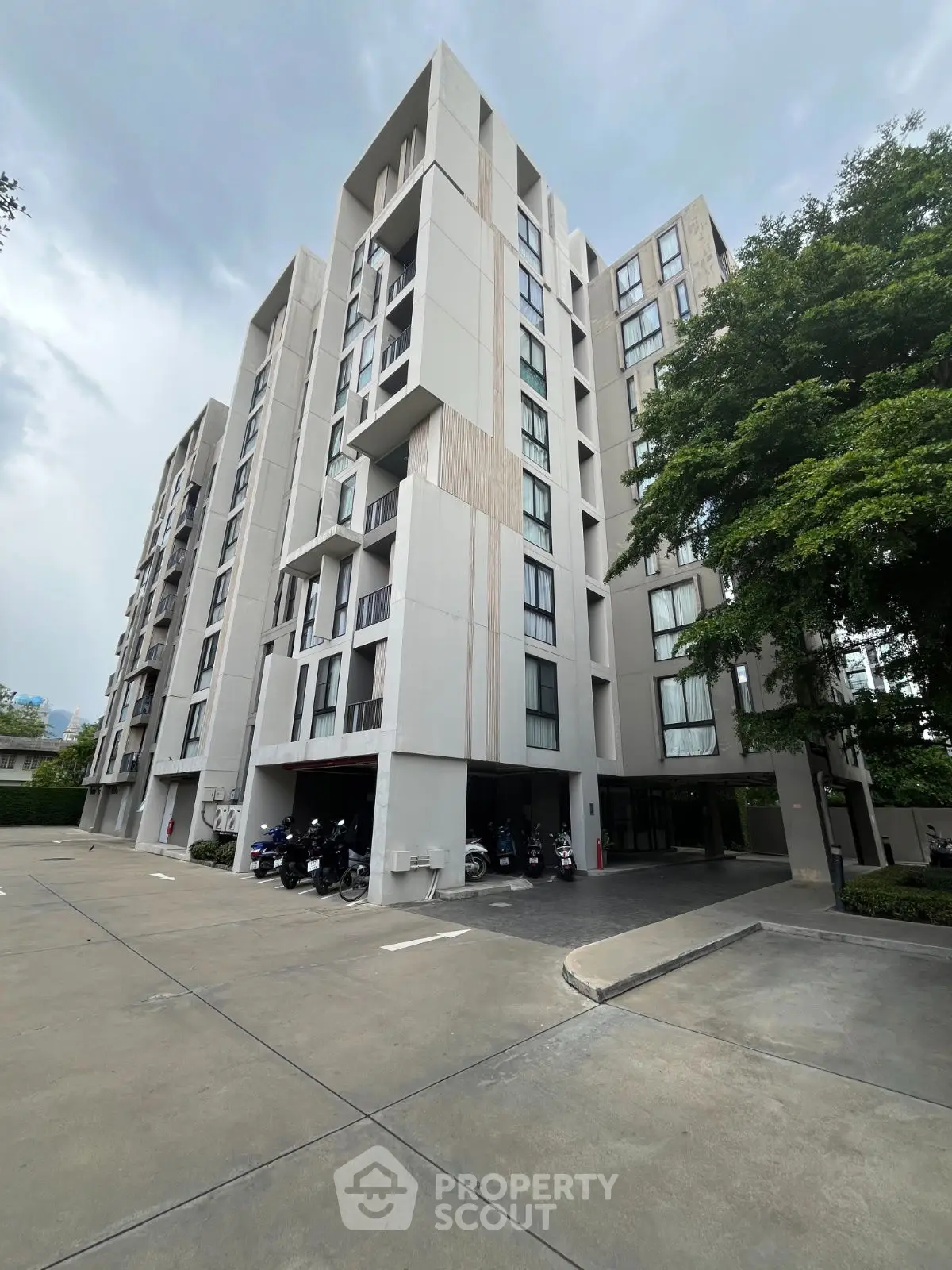 Modern apartment building with sleek design and ample parking space