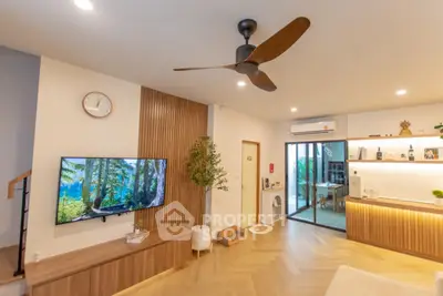 Modern living room with stylish decor and open layout, featuring a ceiling fan and wall-mounted TV.