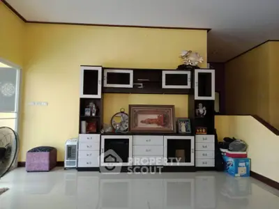 Spacious living room with modern entertainment center and bright yellow walls