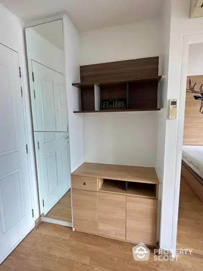 Modern bedroom with wooden flooring and stylish storage unit