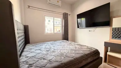 Cozy bedroom with modern decor and wall-mounted TV