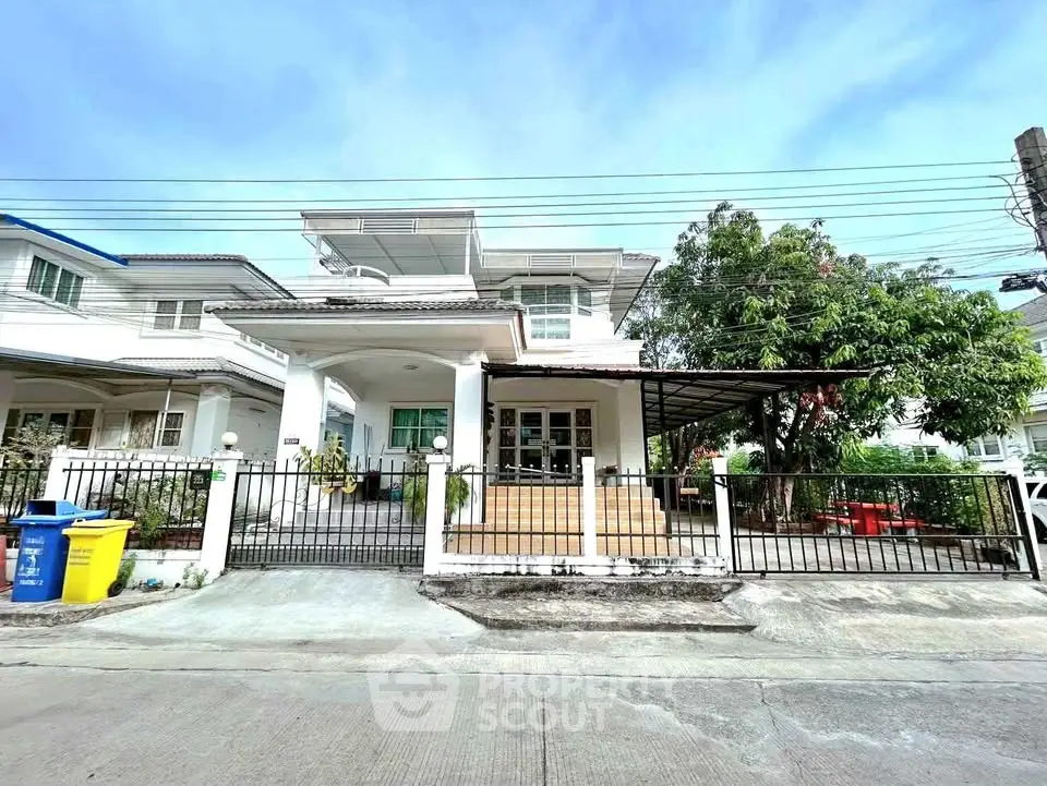 Charming two-story house with spacious front yard and gated entrance in a serene neighborhood.