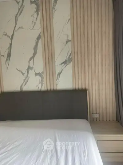 Elegant bedroom with marble accent wall and modern headboard