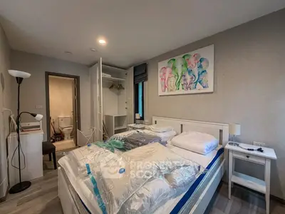 Spacious bedroom with modern decor and ensuite bathroom in a stylish apartment.