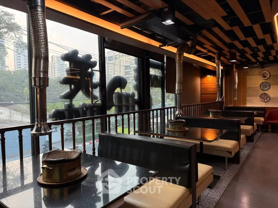 Stylish restaurant interior with city view, featuring modern decor and cozy seating.
