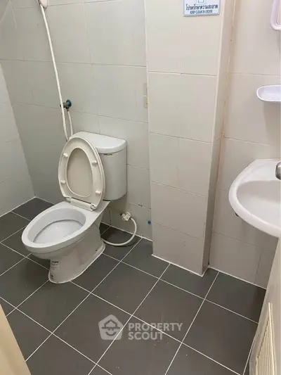 Compact bathroom with modern fixtures and tiled flooring, ideal for efficient space utilization.