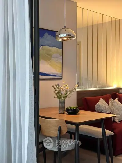 Modern dining area with stylish pendant light and cozy seating in a contemporary apartment.