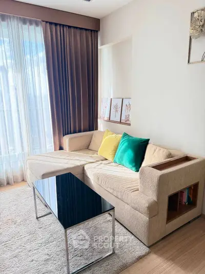 Chic living room with modern sofa, vibrant cushions, and sleek coffee table by sunlit window.