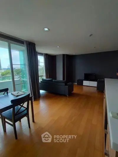 Spacious modern living room with large windows and wooden flooring