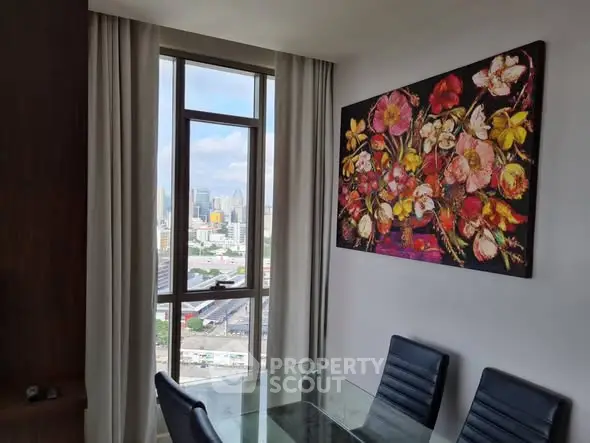 Stylish dining area with city view and vibrant floral artwork, perfect for modern urban living.