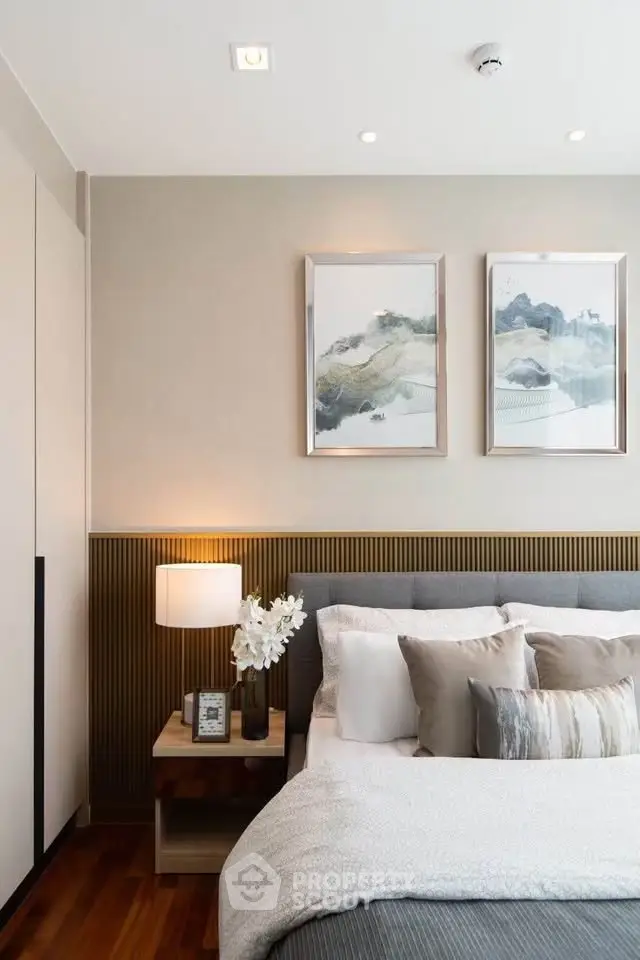 Elegant bedroom with modern decor, featuring cozy bedding and stylish artwork, perfect for a serene retreat.