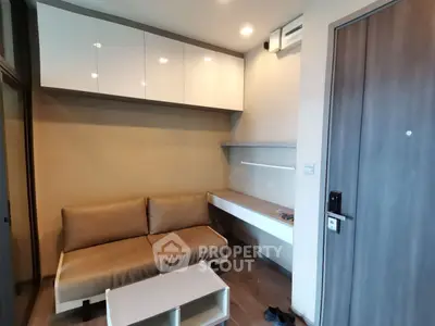 Modern compact living room with sleek furniture and built-in storage solutions.