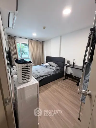 Cozy bedroom with modern decor and ample natural light, featuring a comfortable bed and stylish furnishings.