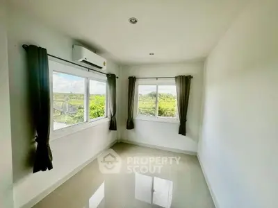 Bright room with large windows offering scenic views of lush greenery, perfect for a serene living space.