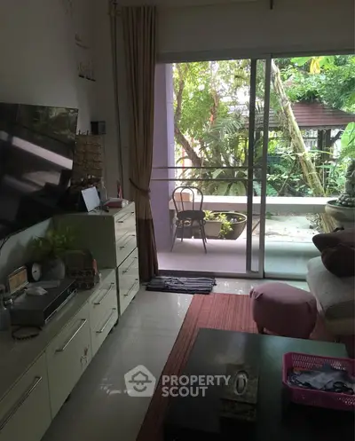 Cozy living room with garden view and sliding glass doors leading to patio.